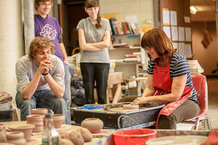 a teacher showing how to make pottery